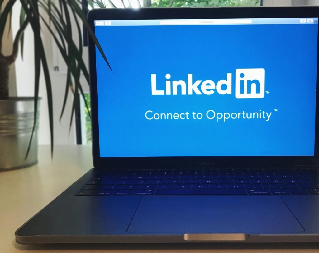 A laptop screen displaying the LinkedIn growth logo with the text 'Connect to Opportunity'.